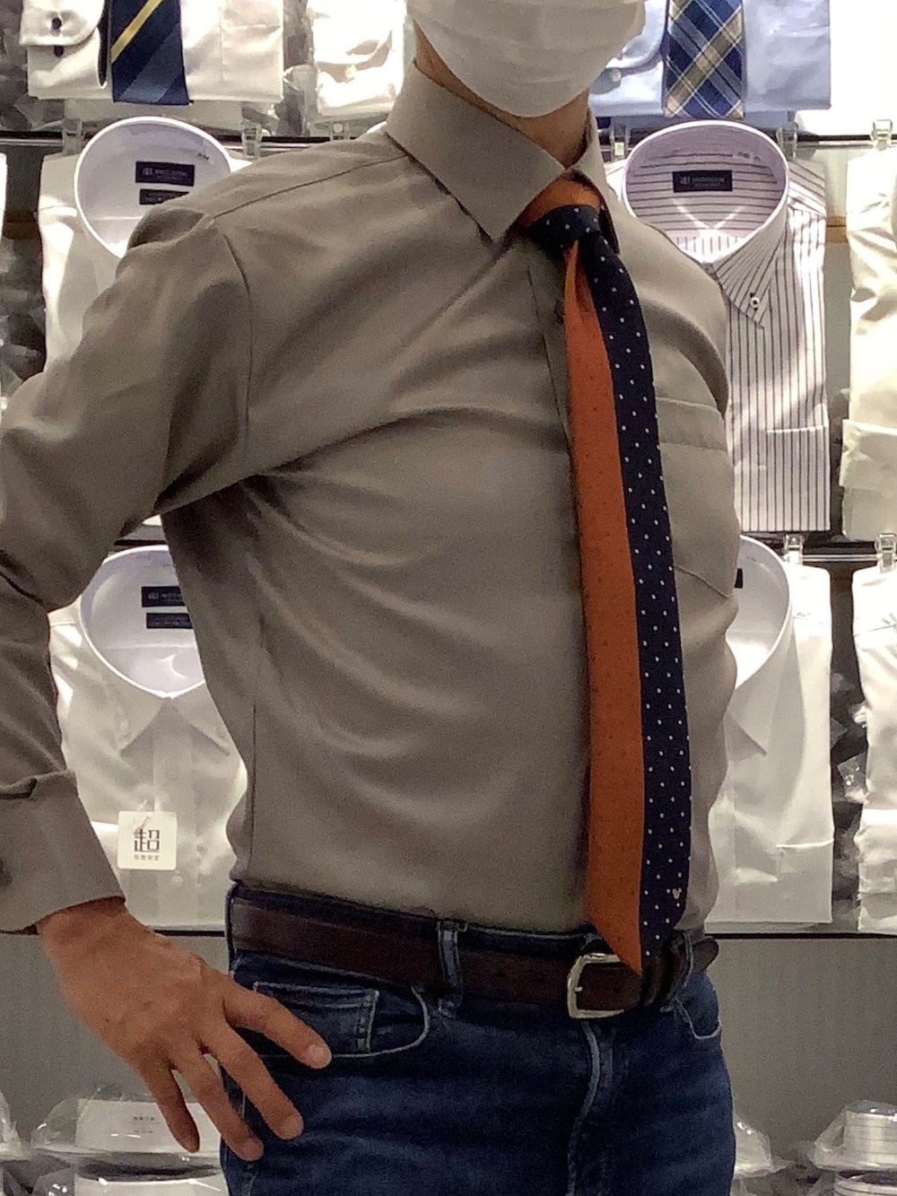 オレンジ系のネクタイ、シルバー系のカフリンクス、ベージュ系のビジネスシャツを着用したメンズの秋コーディネートの2枚目の写真