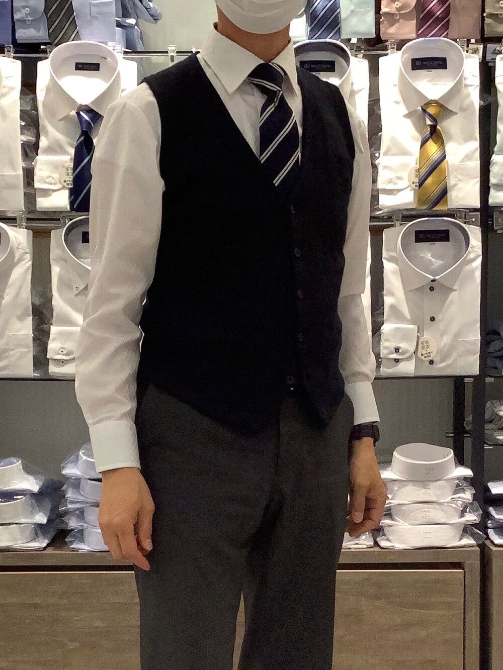 ホワイト系のビジネスシャツ、ブルー系のネクタイ、ブルー系のベストを着用したメンズの冬コーディネートの2枚目の写真