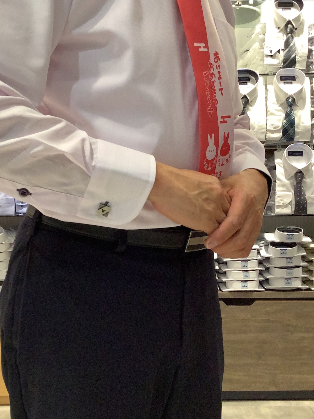 ピンク系のビジネスシャツ、シルバー系のカフリンクス、ブラック系のベルトを着用したメンズの冬コーディネートの3枚目の写真