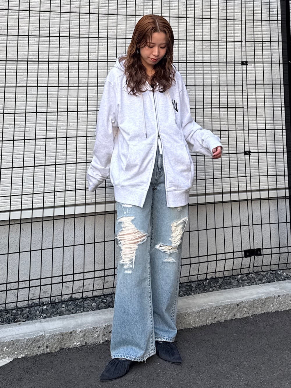 グレー系のパーカー、ブルー系のデニムパンツ、ブラック系のパンプスを着用したレディースの春コーディネートの5枚目の写真