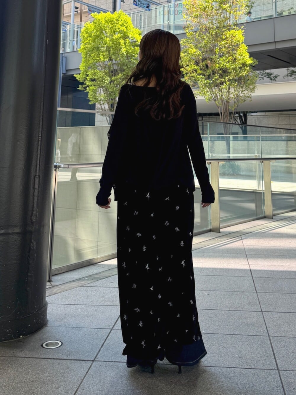 ブルー系のデニムパンツ、ブラック系のパンプス、ブラック系のワンピースを着用したレディースの秋コーディネートの5枚目の写真