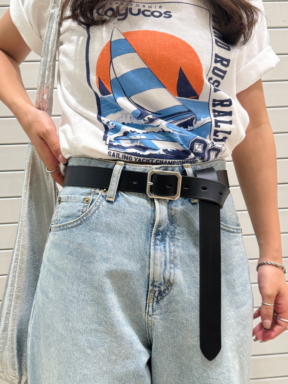 ブルー系のデニムパンツ、ホワイト系のTシャツ/カットソー、ブラック系のベルトを着用したレディースの夏コーディネートの7枚目の写真