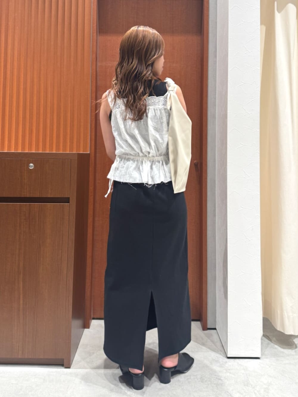 ホワイト系のタンクトップ、ブラック系のワンピース、ブラック系のサンダルを着用したレディースの夏コーディネートの3枚目の写真