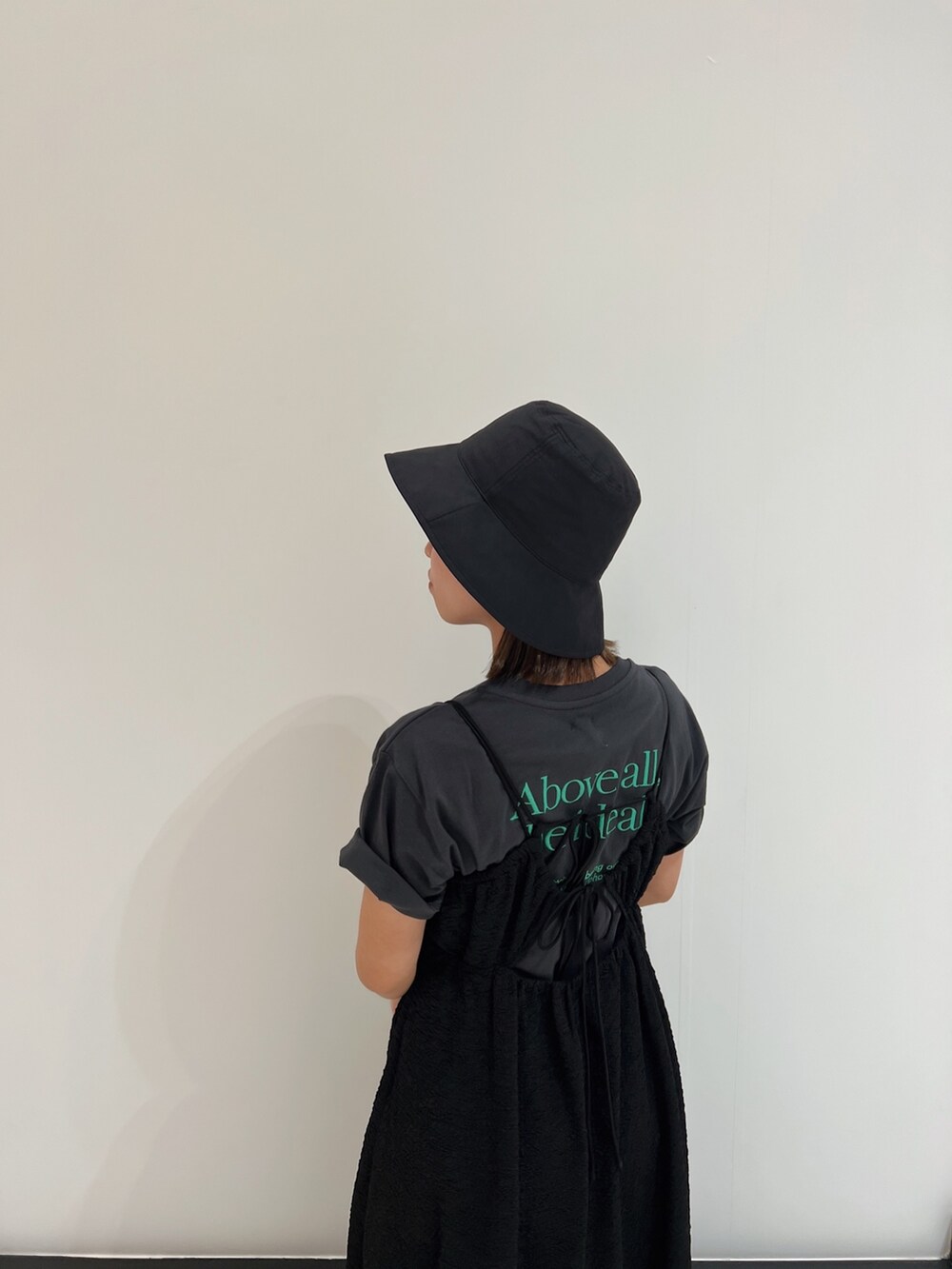 ブラック系のワンピース、グレー系のTシャツ/カットソー、ブラック系のパンプスを着用したレディースの春コーディネートの9枚目の写真