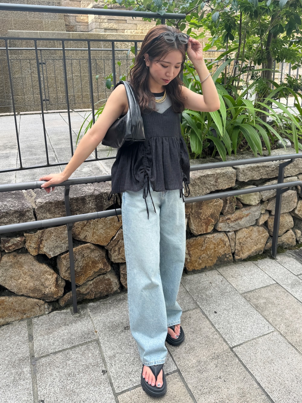 グレー系のタンクトップ、ブラック系のシャツ/ブラウス、ブルー系のデニムパンツを着用したレディースの夏コーディネートの7枚目の写真