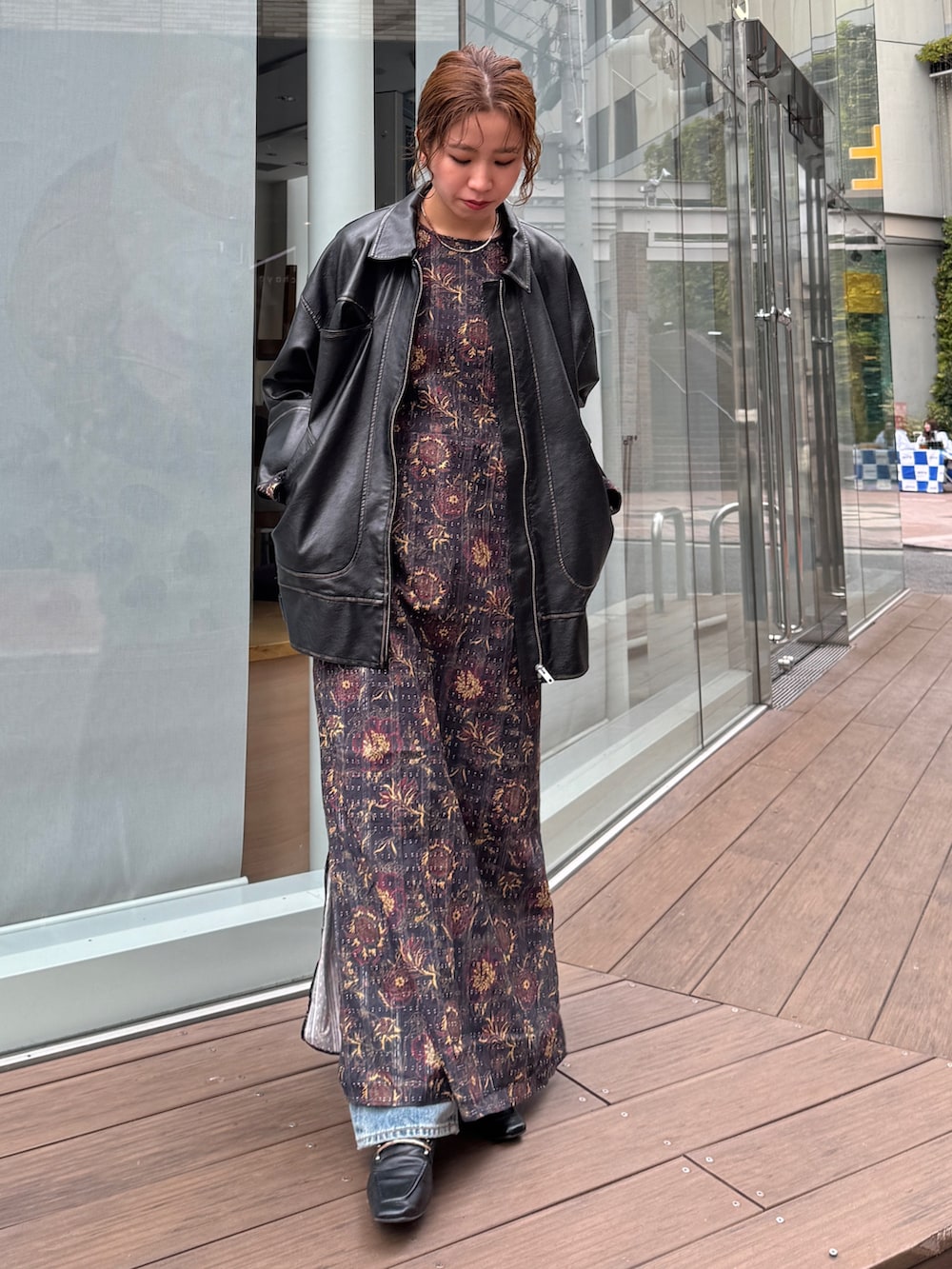 ブラック系のブルゾン、ブラック系のワンピース、ブルー系のデニムパンツを着用したレディースの冬コーディネートの2枚目の写真