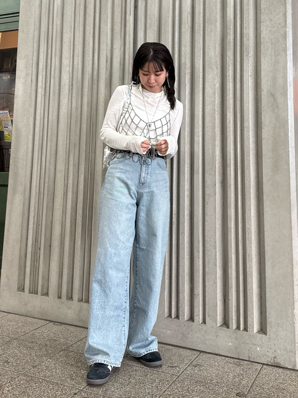 ブラック系のベスト、ブルー系のデニムパンツ、ホワイト系のTシャツ/カットソーを着用したレディースの冬コーディネートの3枚目の写真