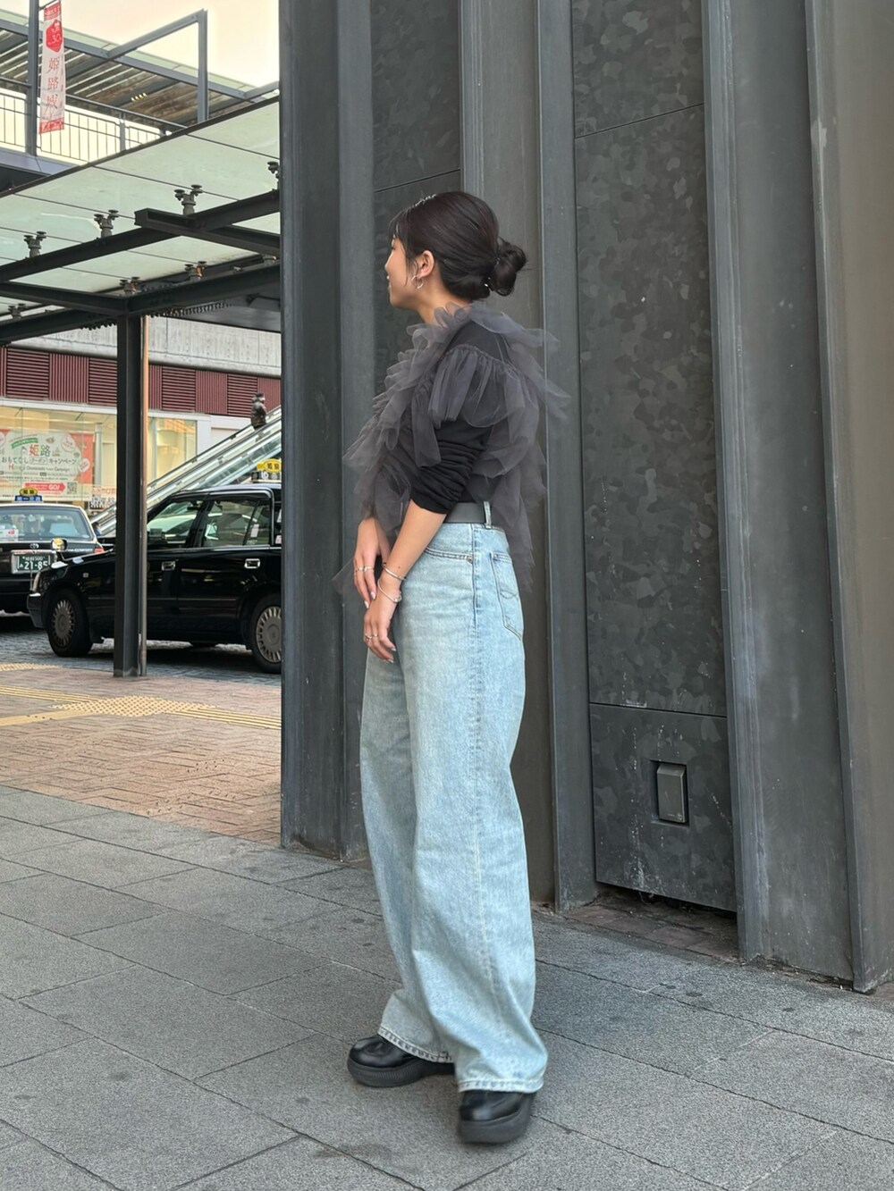 グレー系のベスト、ブラック系のTシャツ/カットソー、ブルー系のデニムパンツを着用したレディースの冬コーディネートの2枚目の写真