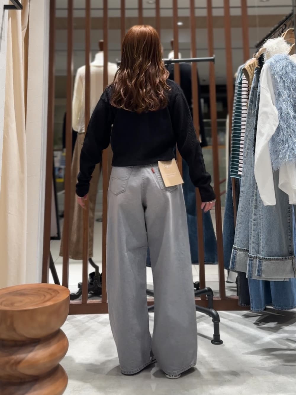 ブルー系のデニムパンツ、ブラック系のカーディガン/ボレロ、パープル系のTシャツ/カットソーを着用したレディースの春コーディネートの6枚目の写真