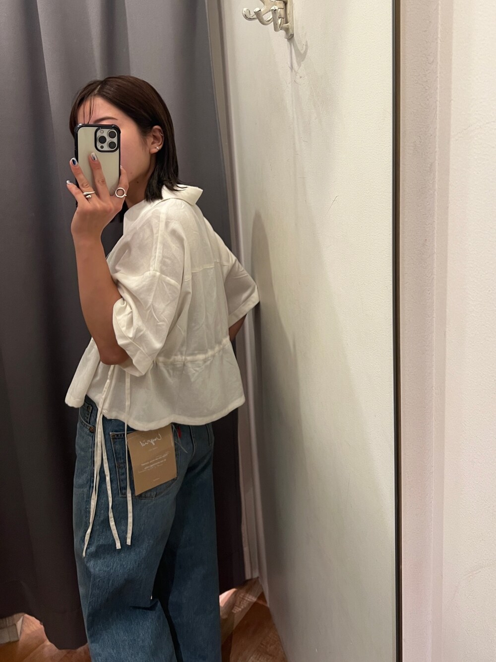 ブルー系のデニムパンツ、ホワイト系のサンダル、ホワイト系のシャツ/ブラウスを着用したレディースの春コーディネートの8枚目の写真
