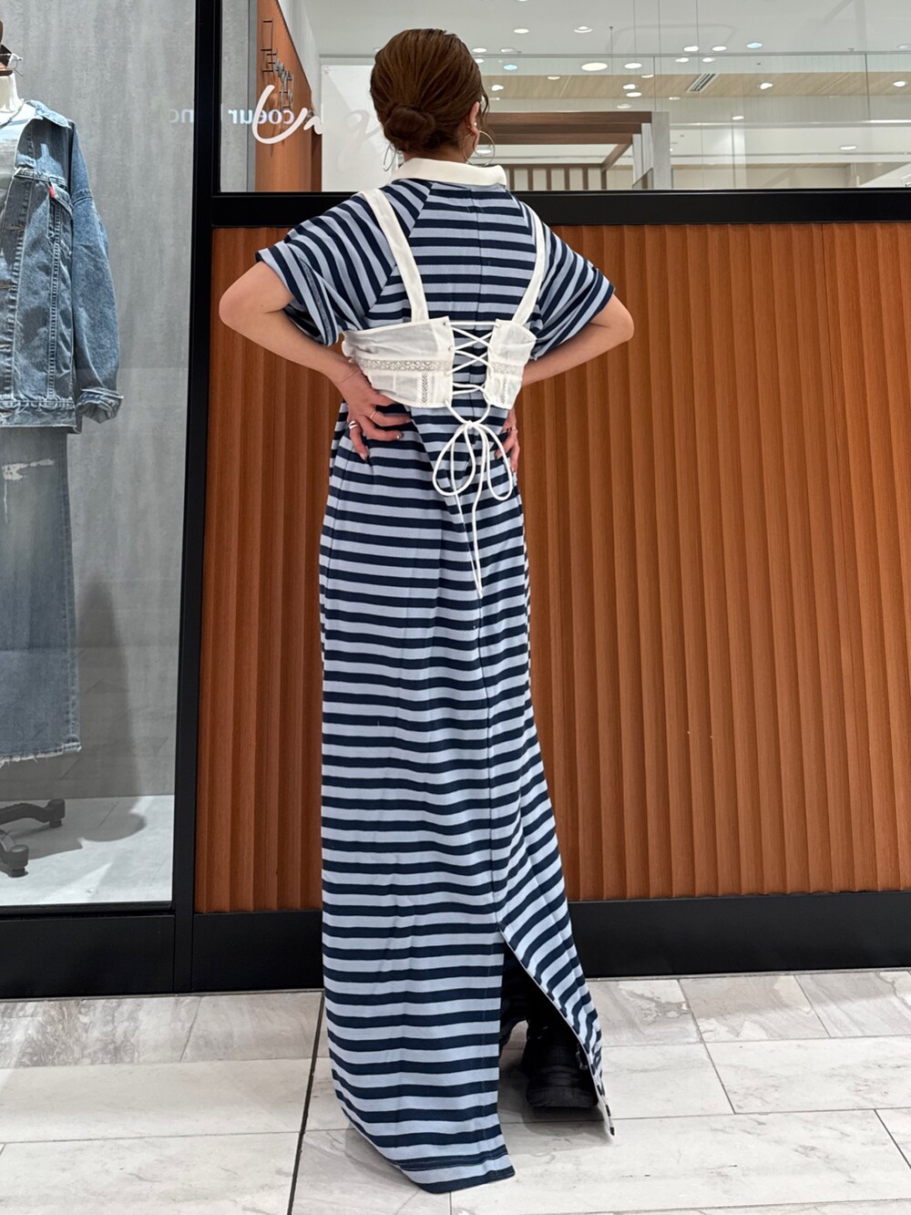 ホワイト系のキャミソール、ブルー系のワンピース、ブラック系のスニーカーを着用したレディースの春コーディネートの4枚目の写真