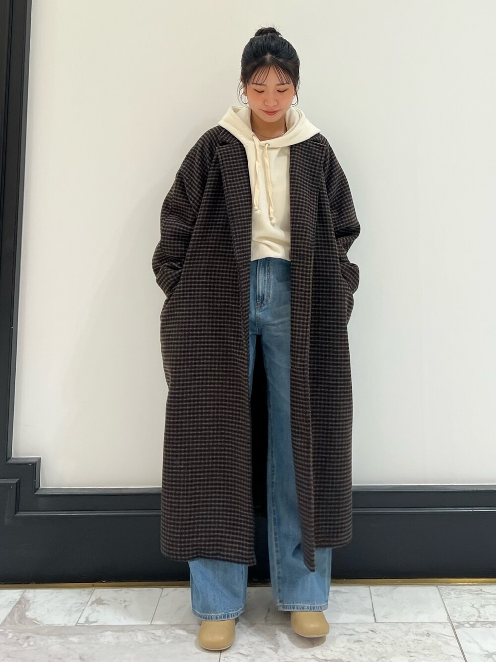 ベージュ系のブーツ、ブルー系のデニムパンツ、その他のチェスターコートを着用したレディースの冬コーディネートの4枚目の写真