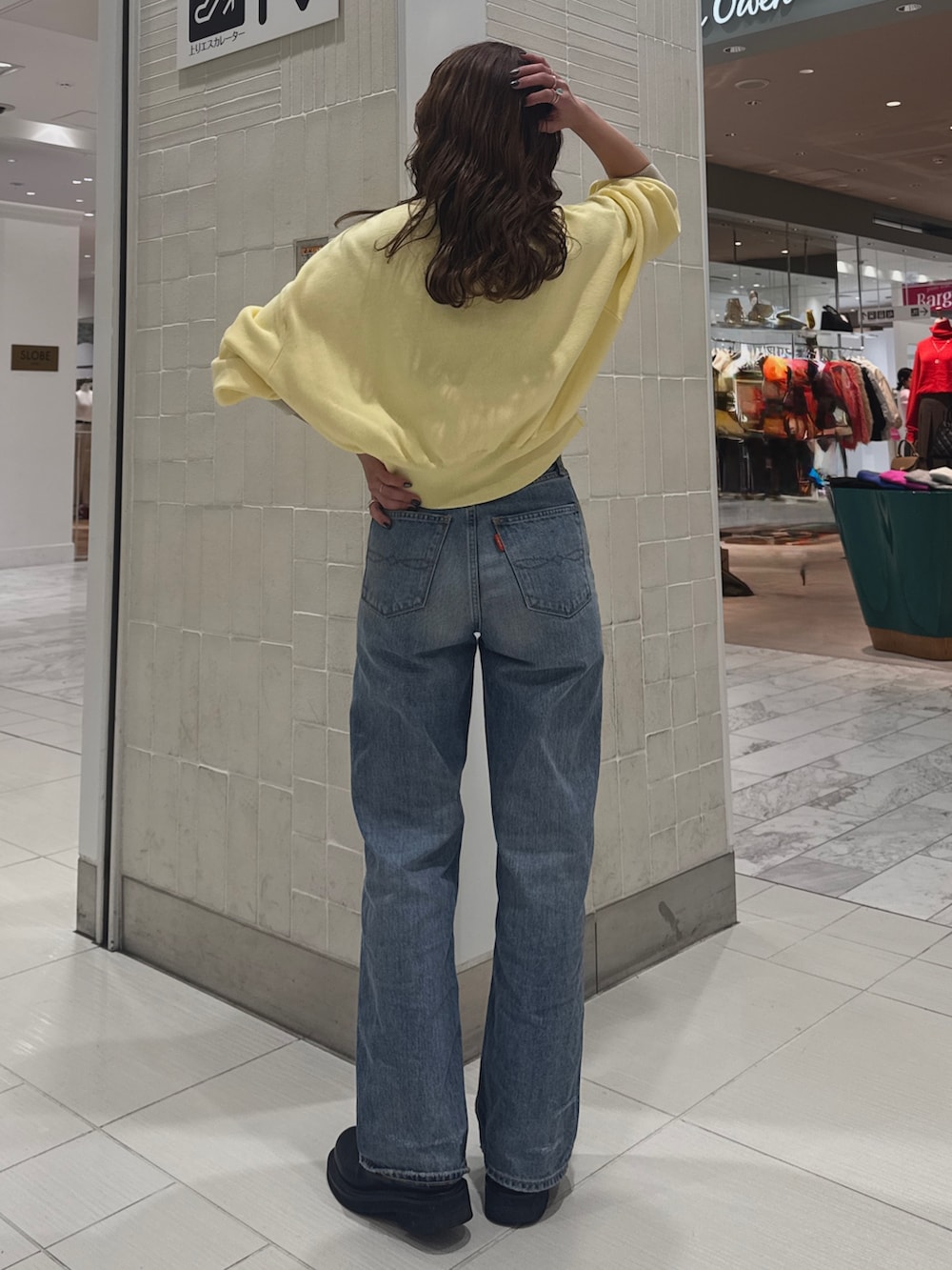 ブルー系のデニムパンツ、ブラック系のブルゾン、イエロー系のニット/セーターを着用したレディースの冬コーディネートの7枚目の写真