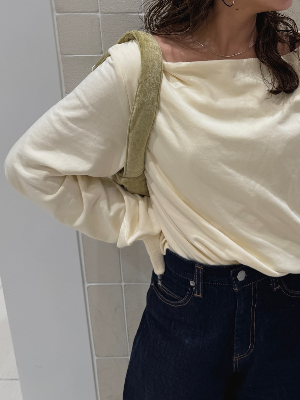 ブルー系のデニムパンツ、ホワイト系のTシャツ/カットソー、グリーン系のハンドバッグを着用したレディースの冬コーディネートの8枚目の写真