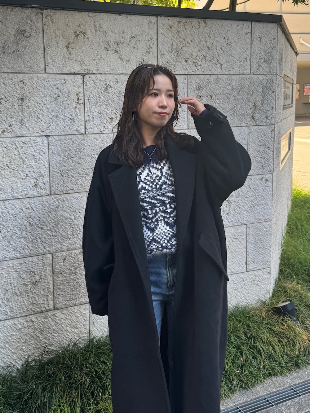 ブルー系のデニムパンツ、ブルー系のニット/セーター、ブラック系のチェスターコートを着用したレディースの秋コーディネートの8枚目の写真