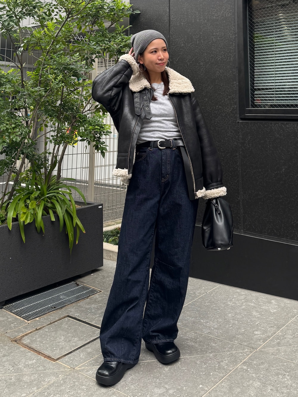 ブラック系のブルゾン、ブルー系のデニムパンツ、グレー系のニット/セーターを着用したレディースの秋コーディネートの6枚目の写真