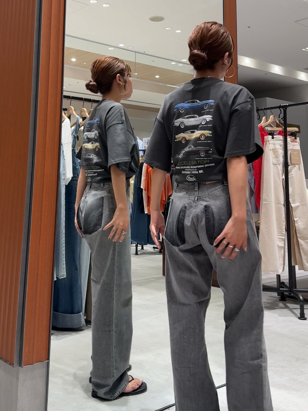 ブラック系のデニムパンツ、グレー系のTシャツ/カットソー、ブラック系のサンダルを着用したレディースの夏コーディネートの4枚目の写真