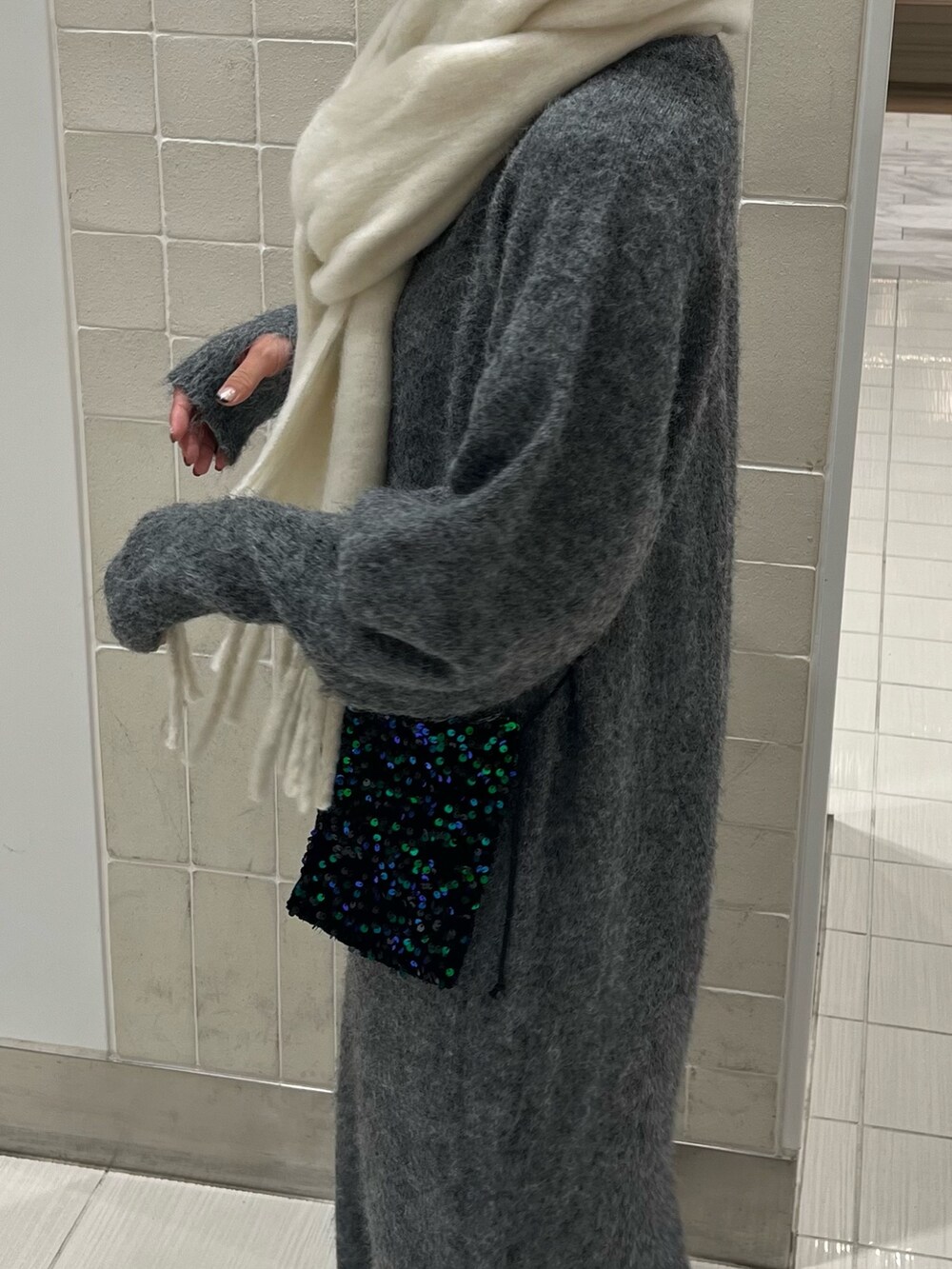 グレー系のワンピース、グリーン系のショルダーバッグ、ホワイト系のマフラーを着用したレディースの秋コーディネートの8枚目の写真