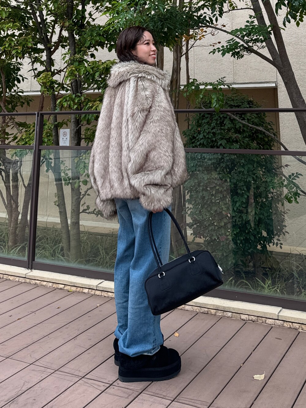 ベージュ系のその他アウター、ブルー系のデニムパンツ、ブラック系のハンドバッグを着用したレディースの秋コーディネートの7枚目の写真