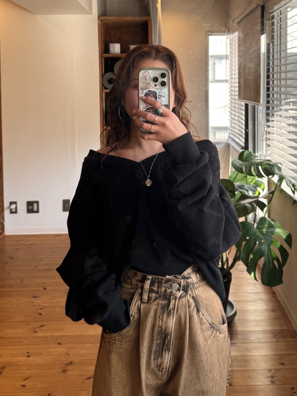 ブラウン系のデニムパンツ、ブラック系のスウェットを着用したレディースの冬コーディネートの10枚目の写真