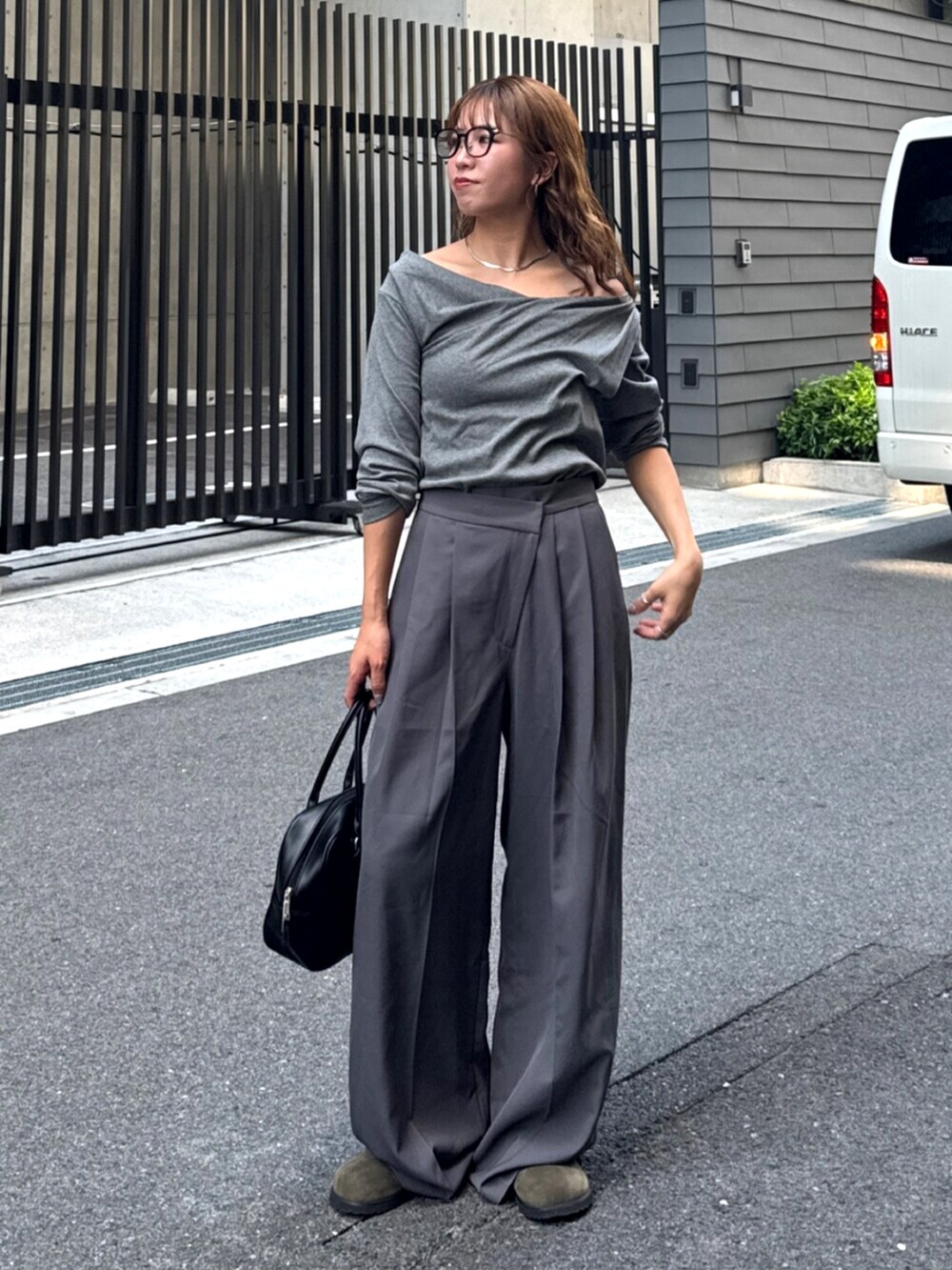 グレー系のその他パンツ、ベージュ系のスリッポン、ブラック系のハンドバッグを着用したレディースの夏コーディネートの2枚目の写真