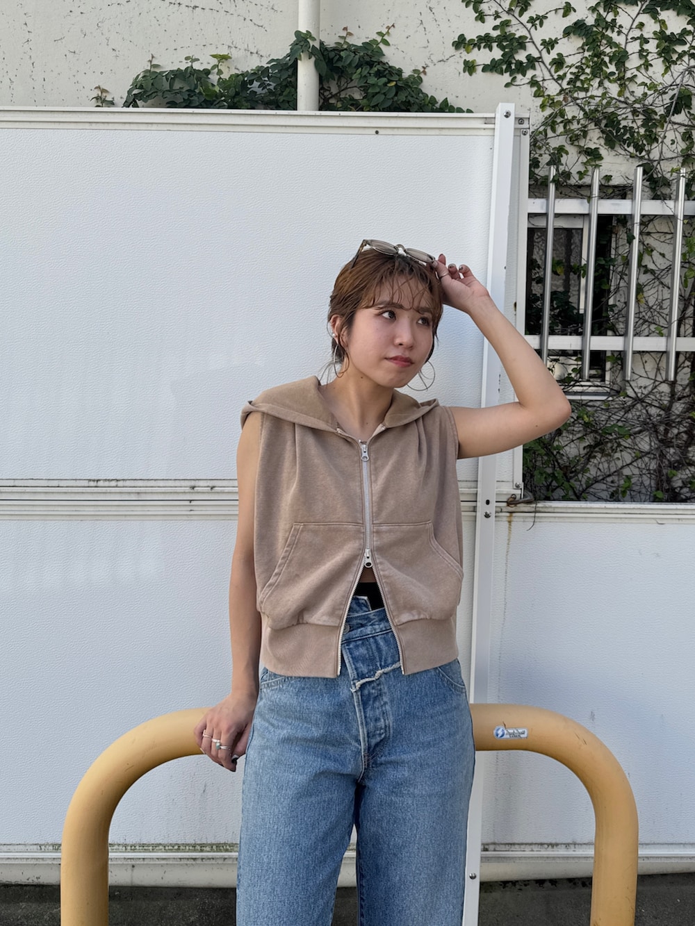 ベージュ系のパーカー、ブルー系のデニムパンツを着用したレディースの夏コーディネートの6枚目の写真