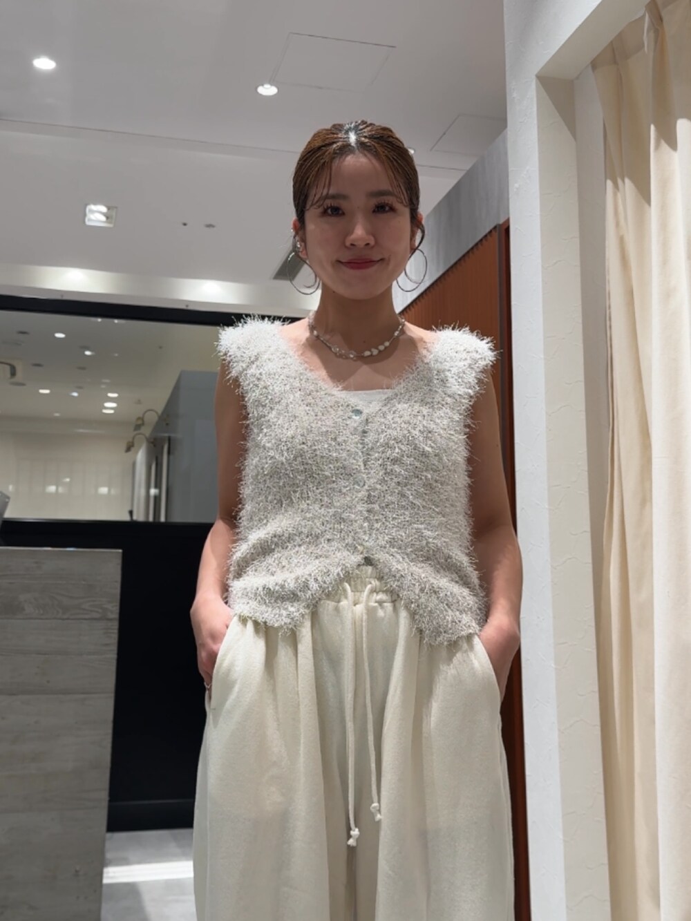 ホワイト系のスウェットパンツ、ホワイト系のベストを着用したレディースの春コーディネートの9枚目の写真