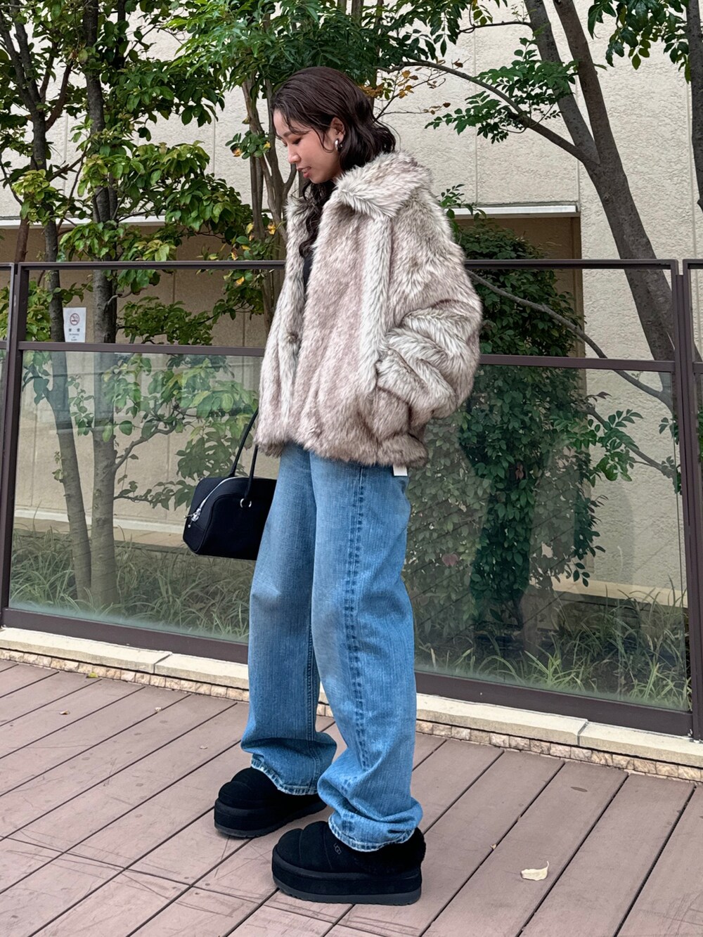 ベージュ系のその他アウター、ブルー系のデニムパンツ、ブラック系のハンドバッグを着用したレディースの秋コーディネートの3枚目の写真