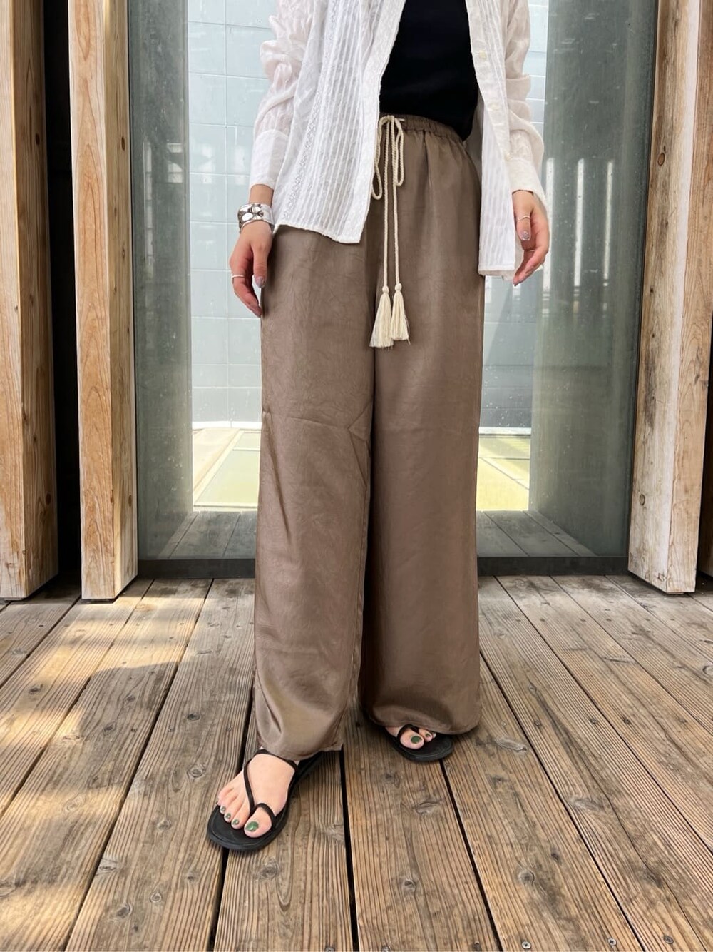 ホワイト系のシャツ/ブラウス、ブラック系のサンダル、ブラウン系のその他パンツを着用したレディースの春コーディネートの5枚目の写真