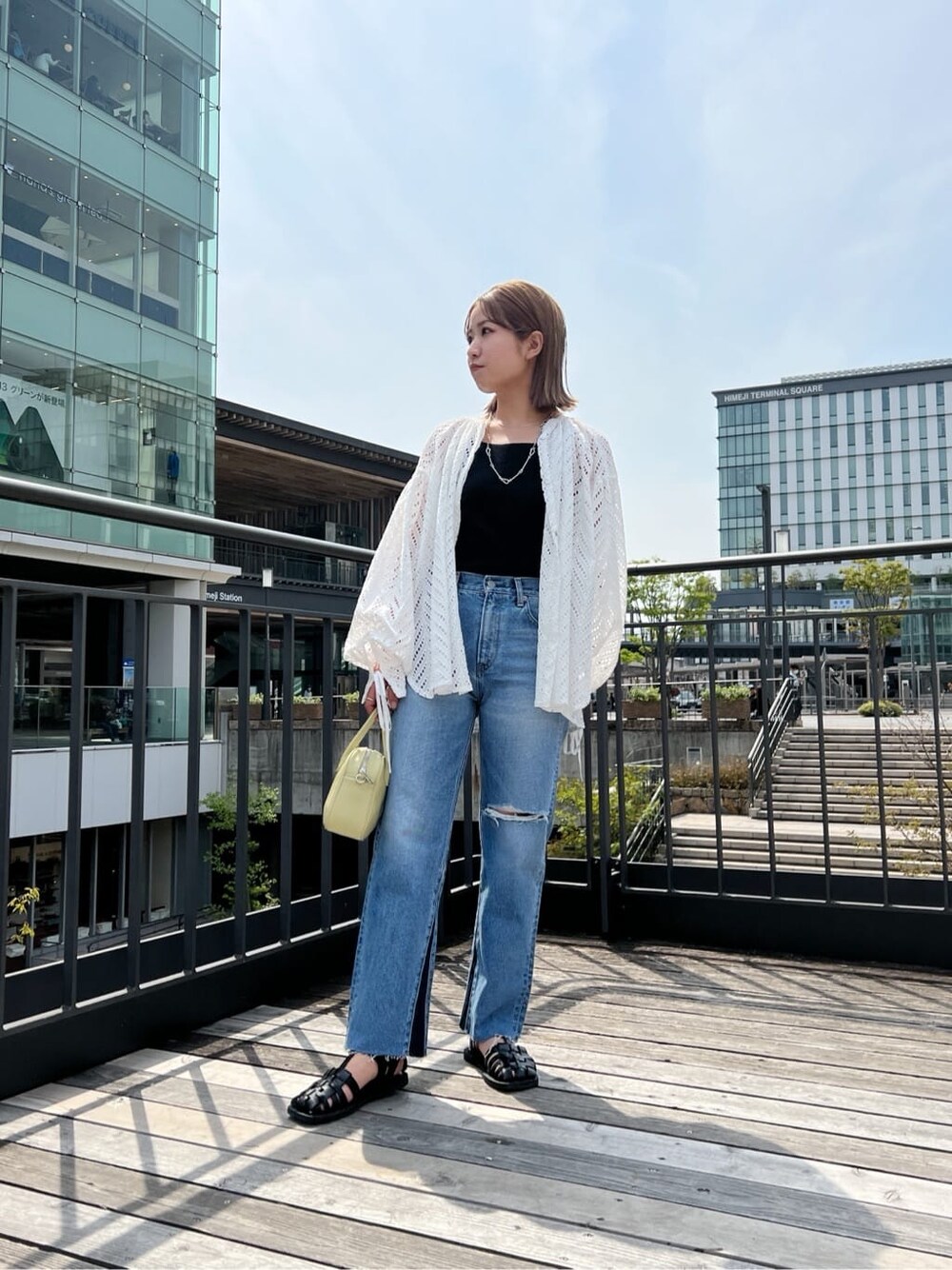 ホワイト系のシャツ/ブラウス、ブルー系のデニムパンツを着用したレディースの春コーディネートの3枚目の写真