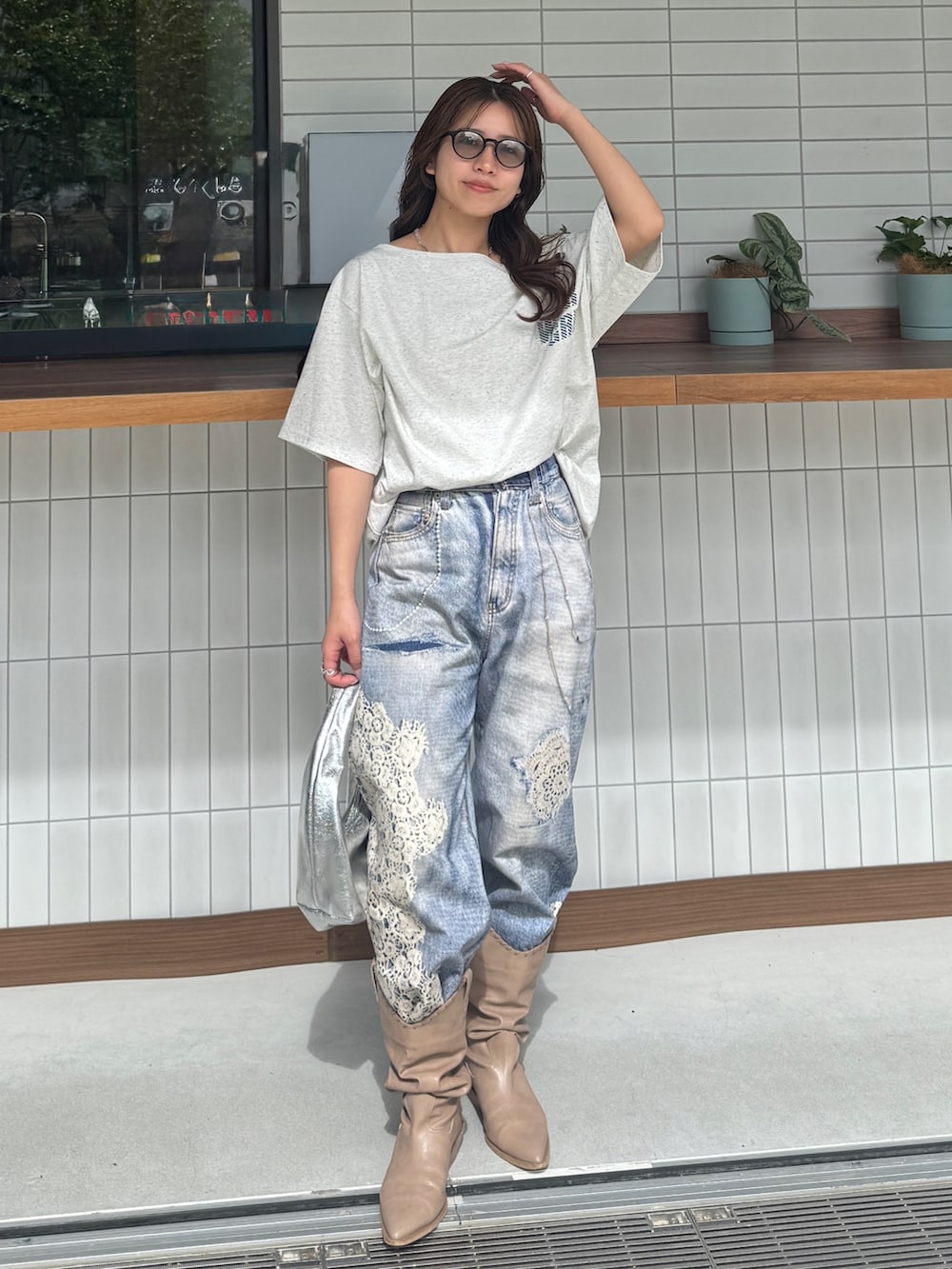 グレー系のTシャツ/カットソー、ブルー系のデニムパンツ、ベージュ系のブーツを着用したレディースの春コーディネートの3枚目の写真