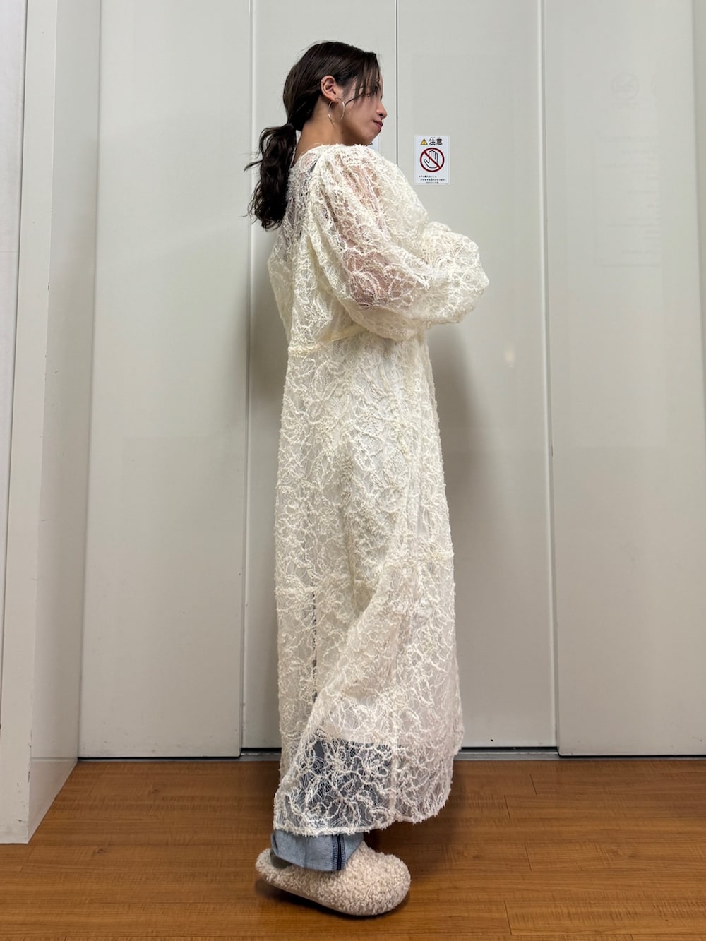 ベージュ系のブルゾン、ホワイト系のワンピース、ブルー系のデニムパンツを着用したレディースの冬コーディネートの9枚目の写真