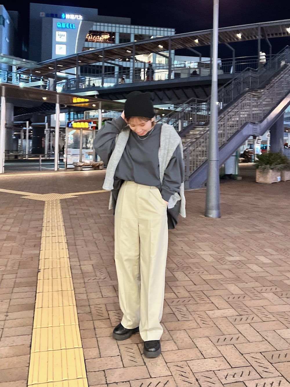 グレー系のTシャツ/カットソー、グレー系のニット/セーター、ベージュ系のスラックスを着用したレディースの冬コーディネートの2枚目の写真