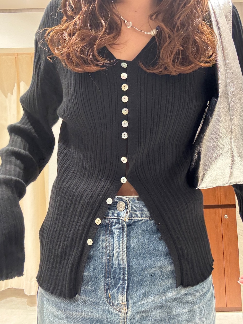 ブルー系のデニムパンツ、ブラック系のカーディガン/ボレロ、ブラック系のパンプスを着用したレディースの春コーディネートの7枚目の写真