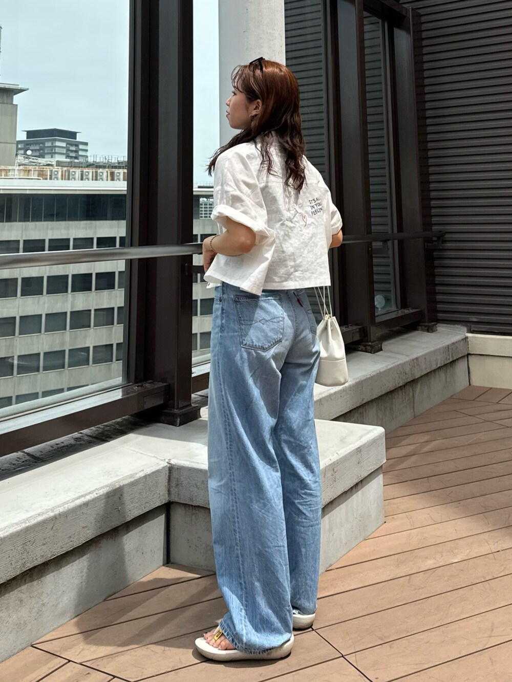 ブルー系のデニムパンツ、グレー系のTシャツ/カットソー、ホワイト系のシャツ/ブラウスを着用したレディースの夏コーディネートの9枚目の写真