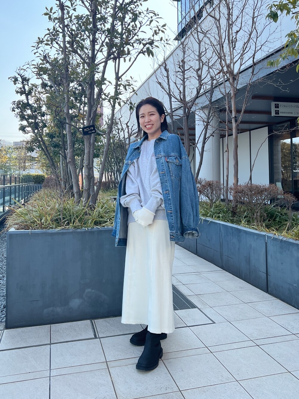 ブルー系のデニムジャケット、グレー系のスウェット、ホワイト系のワンピースを着用したレディースの冬コーディネートの3枚目の写真