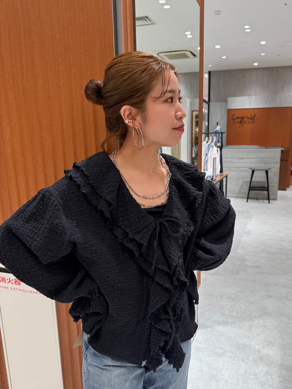 ブルー系のデニムパンツ、ブラック系のシャツ/ブラウス、ホワイト系のパンプスを着用したレディースの春コーディネートの7枚目の写真