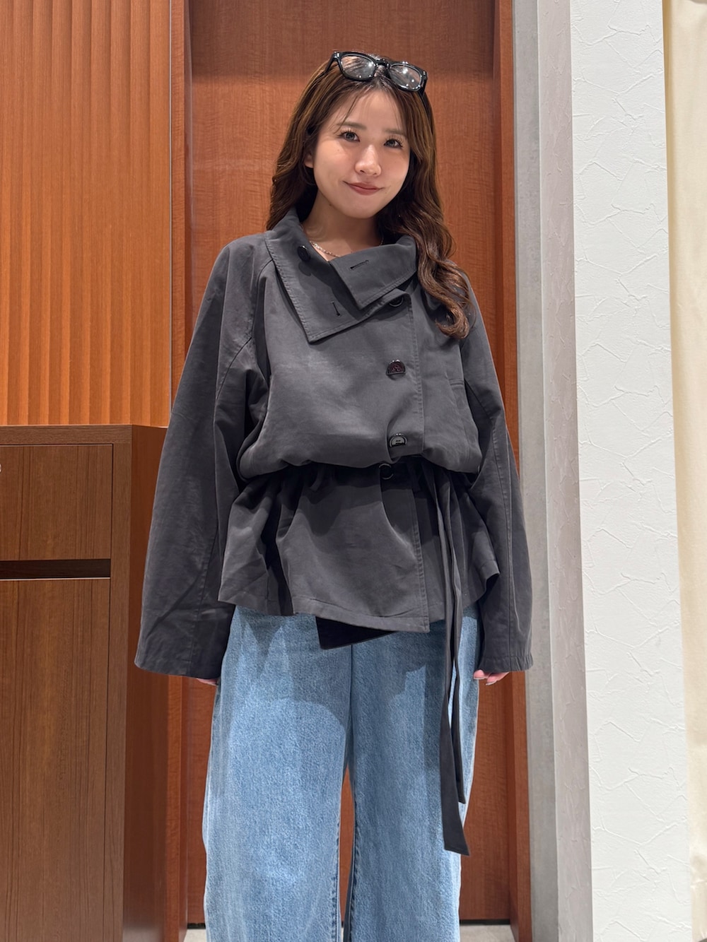 グレー系のトレンチコート、ブルー系のデニムパンツ、シルバー系のネックレスを着用したレディースの秋コーディネートの6枚目の写真