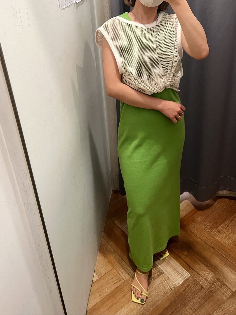 グリーン系のワンピース、グリーン系のサンダル、ベージュ系のタンクトップを着用したレディースの夏コーディネートの3枚目の写真