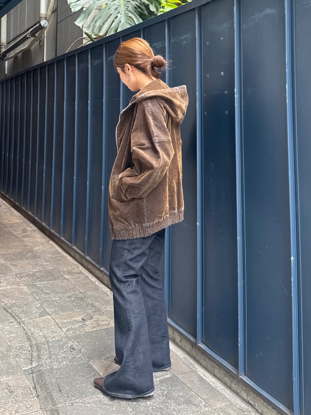 ブラック系のニット/セーター、ブラウン系のブルゾン、ブルー系のデニムパンツを着用したレディースの秋コーディネートの4枚目の写真