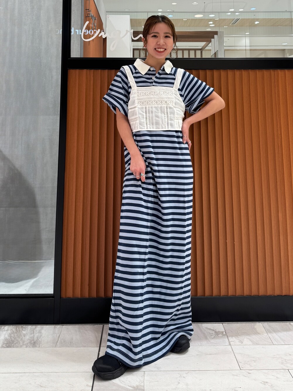 ホワイト系のキャミソール、ブルー系のワンピース、ブラック系のスニーカーを着用したレディースの春コーディネートの2枚目の写真