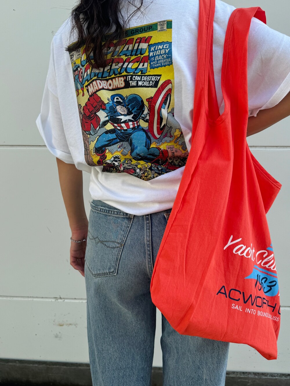 ブルー系のデニムパンツ、ホワイト系のTシャツ/カットソー、オレンジ系のエコバッグ/サブバッグを着用したレディースの夏コーディネートの9枚目の写真