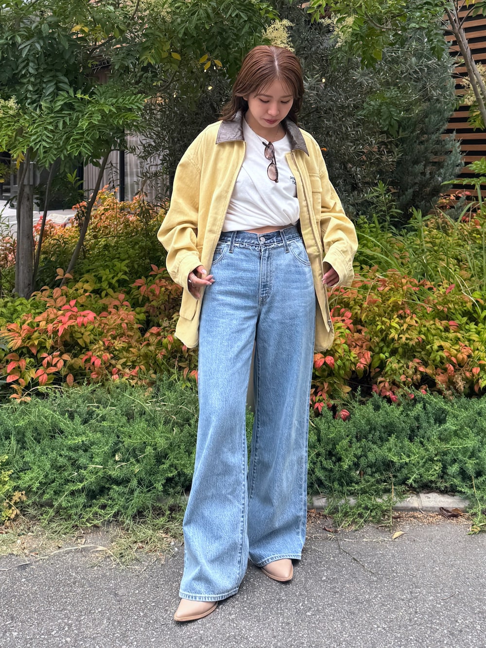 ブルー系のデニムパンツ、イエロー系のブルゾン、ホワイト系のTシャツ/カットソーを着用したレディースの夏コーディネートの2枚目の写真