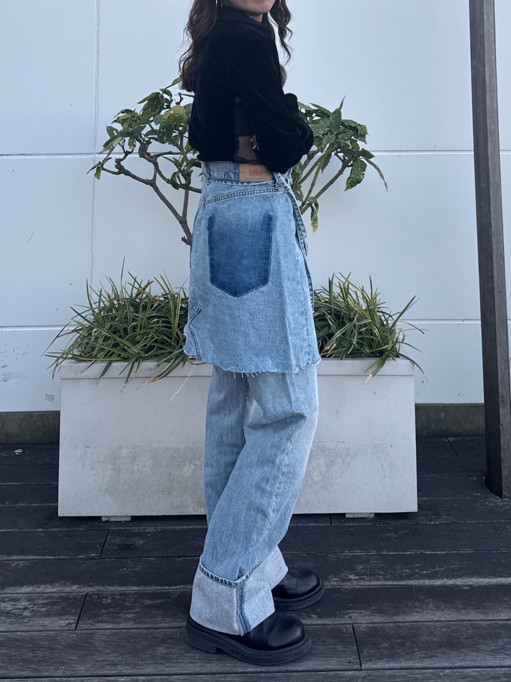 ブラック系のTシャツ/カットソー、ブルー系のスカート、ブルー系のデニムパンツを着用したレディースの冬コーディネートの2枚目の写真