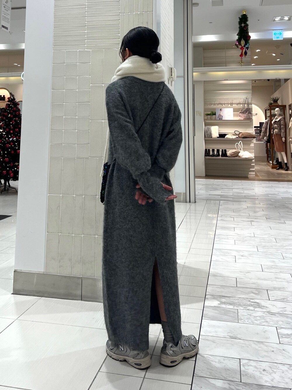 グレー系のワンピース、グリーン系のショルダーバッグ、ホワイト系のマフラーを着用したレディースの秋コーディネートの4枚目の写真