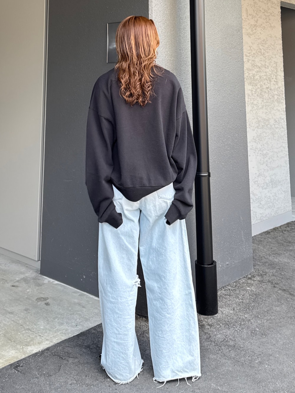 ブラック系のスウェット、グレー系のTシャツ/カットソー、ブルー系のデニムパンツを着用したレディースの春コーディネートの5枚目の写真