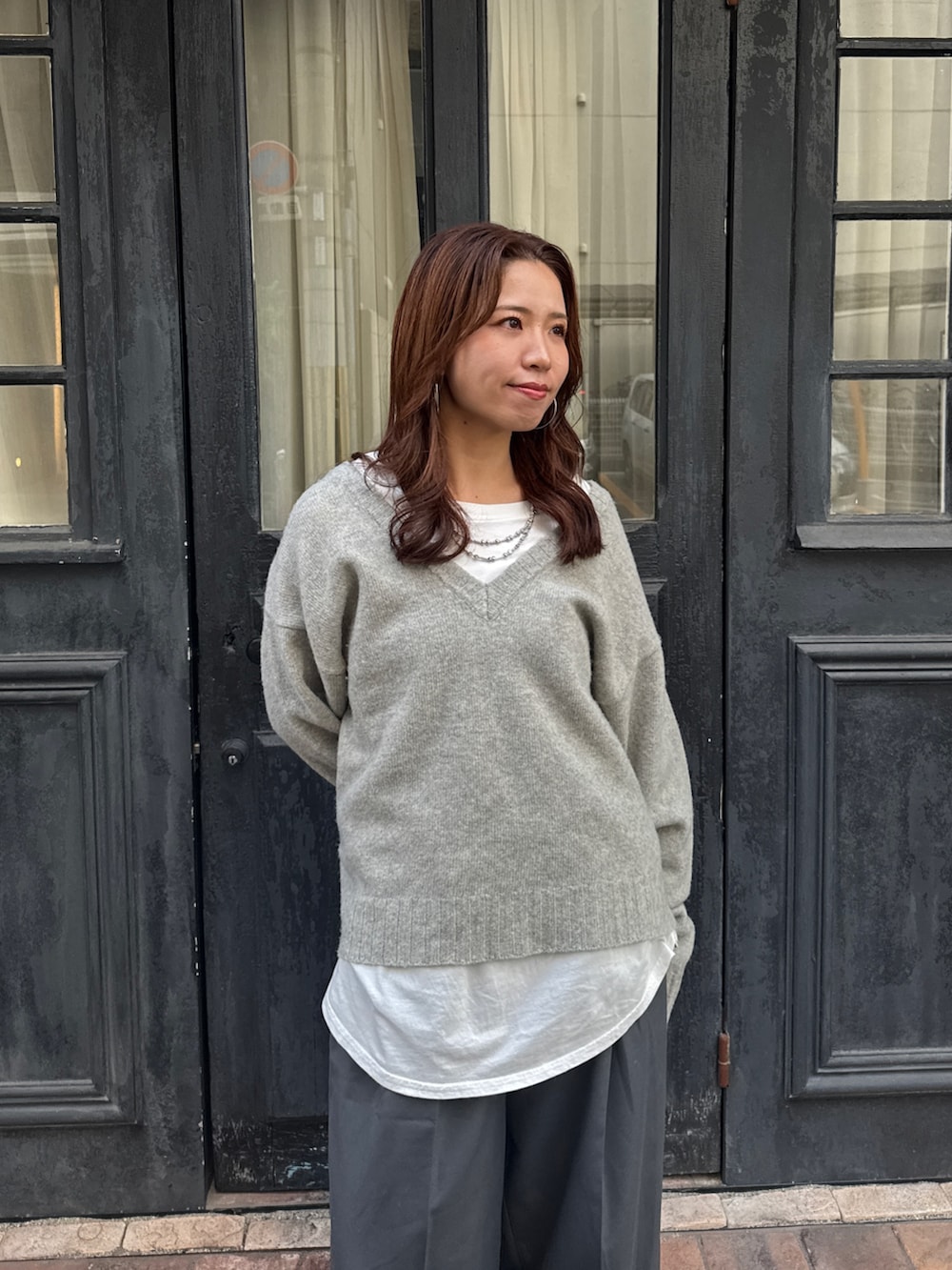 グレー系のニット/セーター、ホワイト系のTシャツ/カットソー、グレー系のその他パンツを着用したレディースの冬コーディネートの8枚目の写真