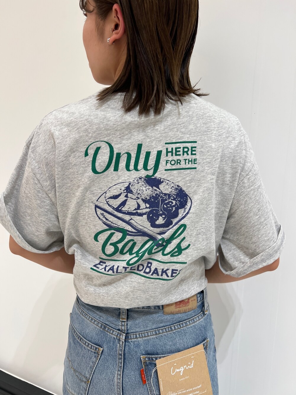 ブルー系のデニムパンツ、グレー系のTシャツ/カットソー、ホワイト系のスニーカーを着用したレディースの春コーディネートの2枚目の写真