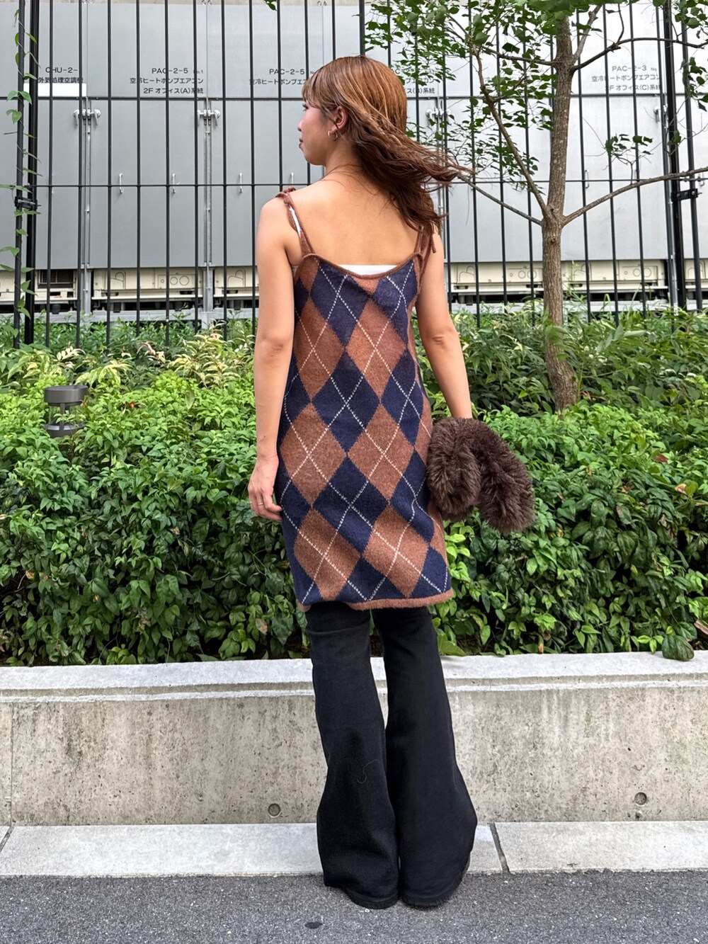 ブラウン系のニット/セーター、ブラック系のデニムパンツ、ブラウン系のハンドバッグを着用したレディースの夏コーディネートの3枚目の写真