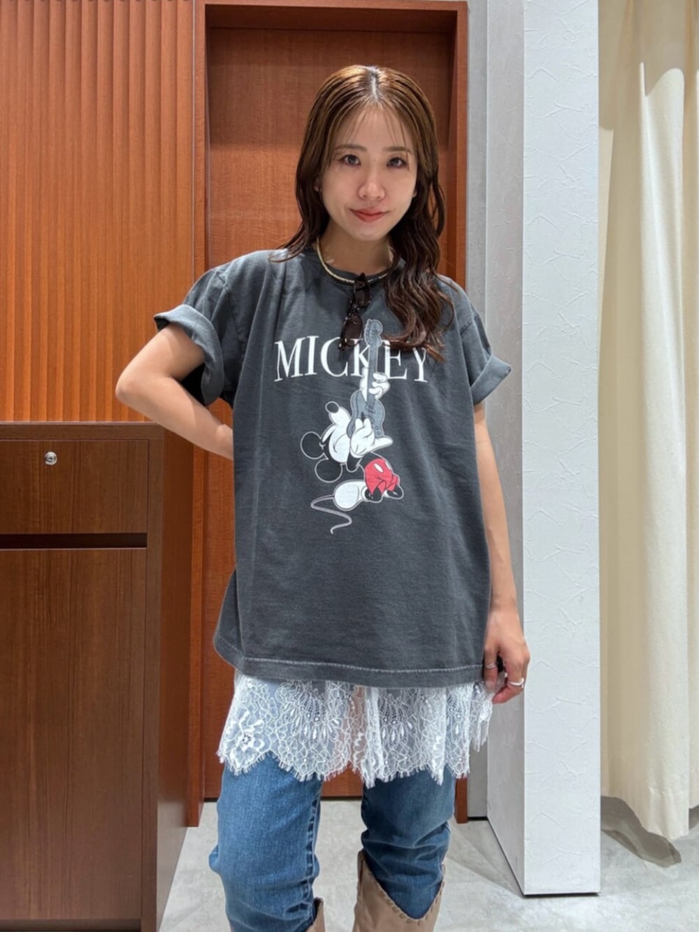 ベージュ系のブーツ、ブルー系のデニムパンツ、ホワイト系のキャミソールを着用したレディースの夏コーディネートの7枚目の写真